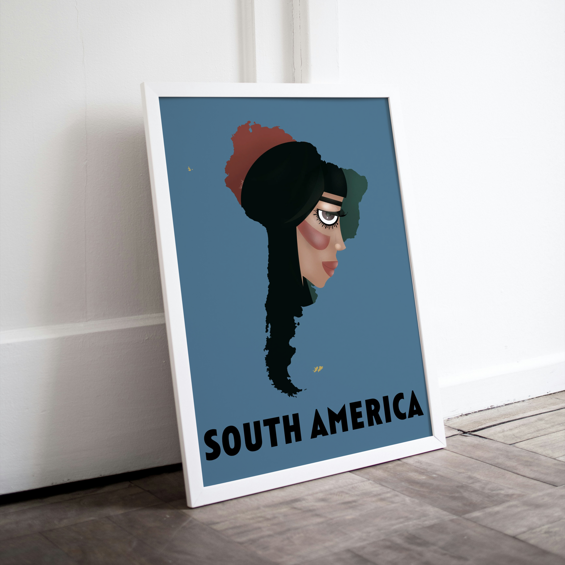 Framed artwork of a stylized face with 'South America' text on a blue background, leaning against a white wall.