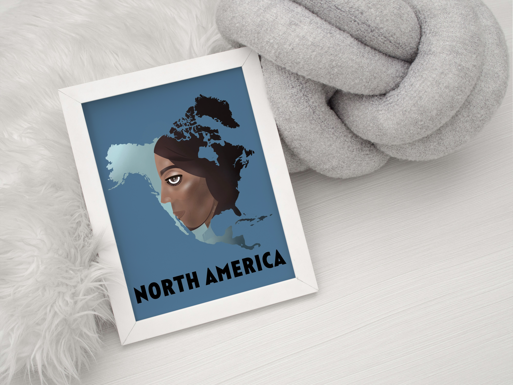 Framed artwork of a map of North America with a person's face, on a white surface.